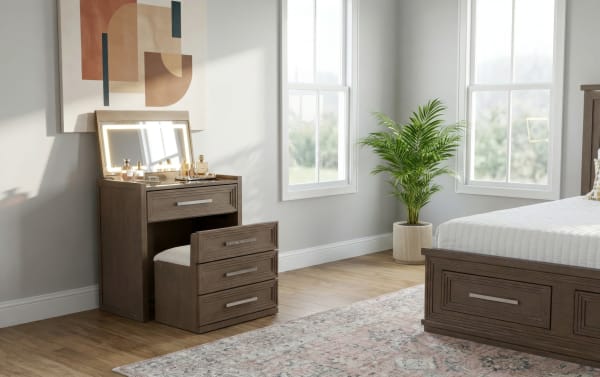 Wooden vanity set with built-in LED mirror, cushioned stool, and storage drawers in a modern bedroom with natural light and a potted plant.