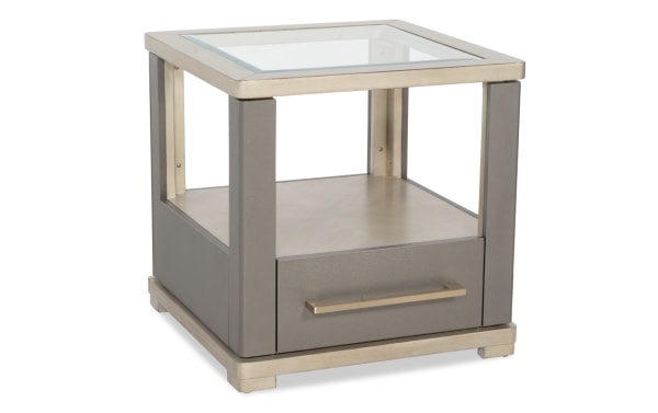 Modern square side table with a glass top, gray faux leather panels, metal frame, and a single drawer with a metal handle.