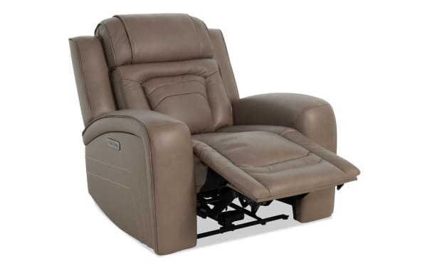 Brown leather recliner chair with padded armrests and cushioned footrest extended, showcasing comfort and modern design.
