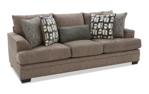 Brown fabric sofa with plush cushions, including patterned and solid throw pillows, featuring a modern, comfortable design ideal for living rooms.