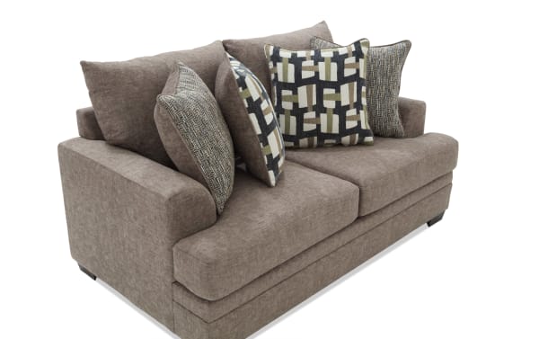 Brown fabric loveseat sofa with thick cushions and four decorative throw pillows in geometric and textured patterns, modern style seating.