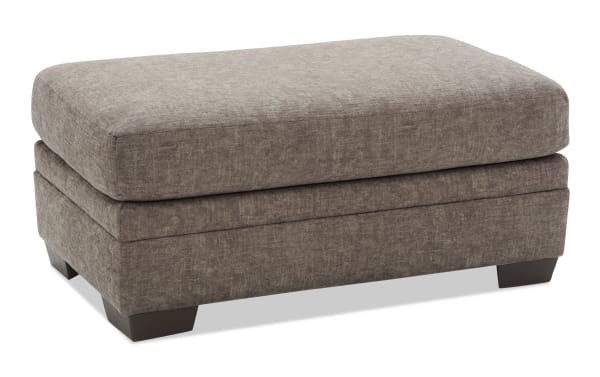 Rectangular brown fabric ottoman with cushioned top and dark wooden legs, suitable for living room seating or footrest.