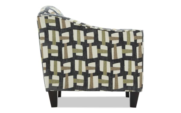 Upholstered armchair with a geometric pattern in beige, olive, and brown tones on a dark background, featuring tapered black wooden legs.