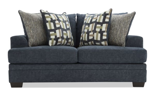 Dark blue upholstered loveseat with plush cushions, featuring patterned throw pillows in geometric and textured designs, ideal for modern living rooms.