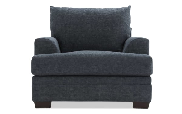 Dark gray upholstered armchair with plush cushions, wide seat, and wooden block legs, designed for comfortable living room seating.