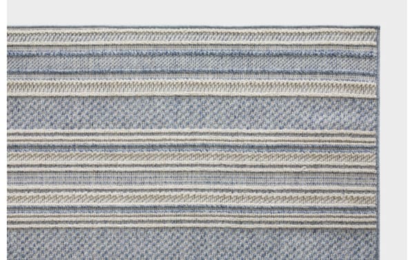 Blue and beige striped woven rug with textured patterns, featuring horizontal bands in soft, neutral tones, suitable for home decor.