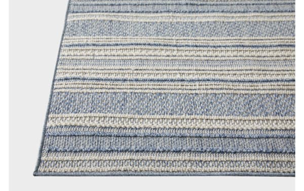 Blue and beige striped woven area rug with textured horizontal patterns and a tightly bound edge, suitable for living room or bedroom decor.