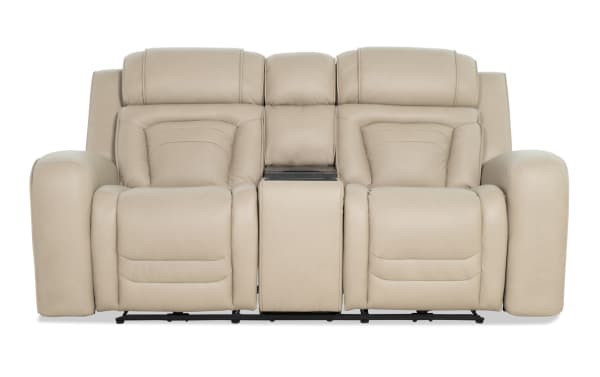 Beige leather dual recliner loveseat with padded armrests, headrests, and a central console, designed for home theater comfort.
