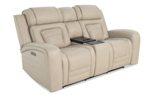 Beige leather reclining loveseat with padded armrests, adjustable headrests, and a central console featuring cup holders and storage, ideal for home theater seating.
