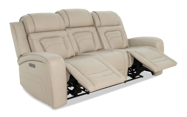 Beige leather reclining sofa with padded armrests and headrests, featuring dual footrests extended for comfort, ideal for living room seating.