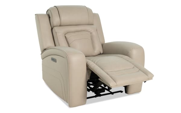 Beige leather power recliner chair with padded armrests, cushioned backrest, and extended footrest, designed for living room comfort.