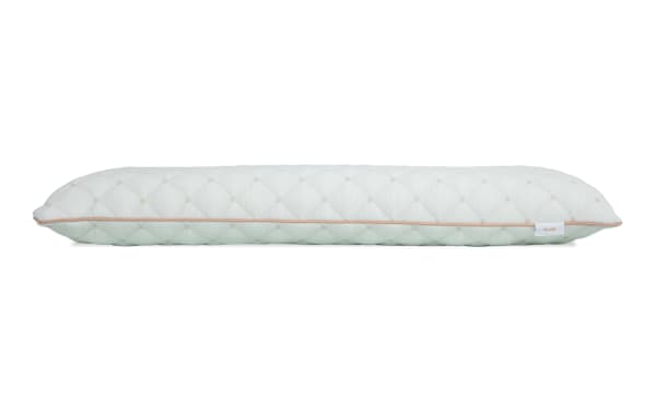 Long, rectangular quilted pillow with a white and light green color scheme, featuring a subtle diamond pattern and a small tag labeled "PLUSH."