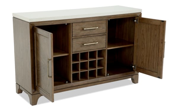 Wooden sideboard cabinet with white countertop, two drawers, two open shelves, two doors, and built-in wine rack, featuring brass handles and a rustic finish.
