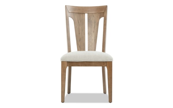 Wooden dining chair with a beige upholstered seat, tapered legs, and a slatted backrest featuring a central vertical panel.