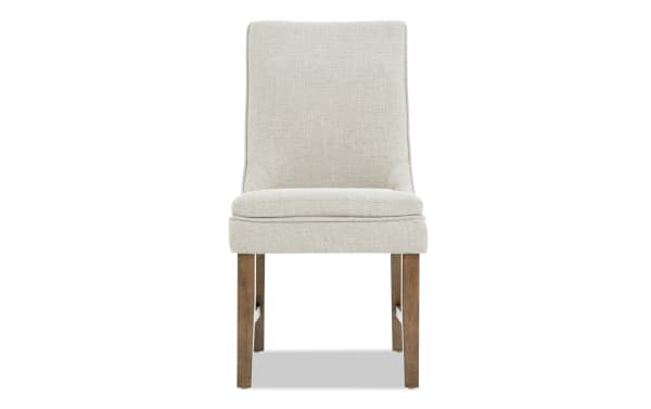 Upholstered dining chair with beige textured fabric, padded seat and backrest, and wooden legs in a natural finish.