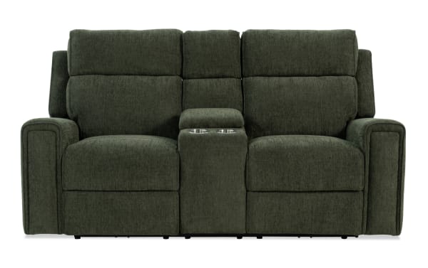 Dark green fabric reclining loveseat with padded armrests, high back cushions, and a center console featuring two metal cup holders.