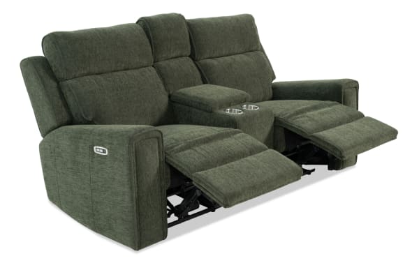 Green fabric reclining loveseat with padded armrests, adjustable footrests, and center console with cup holders, designed for comfort and relaxation.