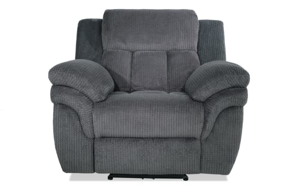Dark gray plush fabric recliner chair with padded armrests and cushioned backrest, designed for comfort and relaxation.