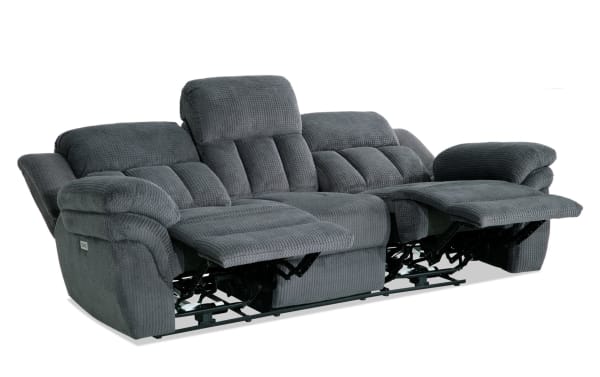Gray fabric reclining sofa with plush cushioning, padded armrests, and adjustable footrests, designed for comfort and relaxation.