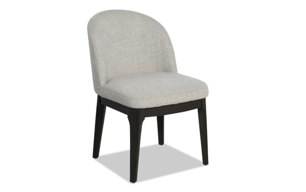 Upholstered dining chair with light gray fabric seat and backrest, dark wooden legs, modern minimalist design.