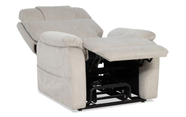 Light gray fabric recliner chair with plush padded armrests and backrest, extended footrest, and visible black metal reclining mechanism.