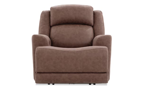 Brown leather recliner chair with cushioned armrests and high backrest, designed for comfort and relaxation in living rooms.