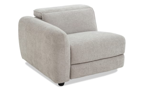 Modern beige fabric armchair with plush cushioning, rounded armrests, and a low backrest, ideal for living room seating.