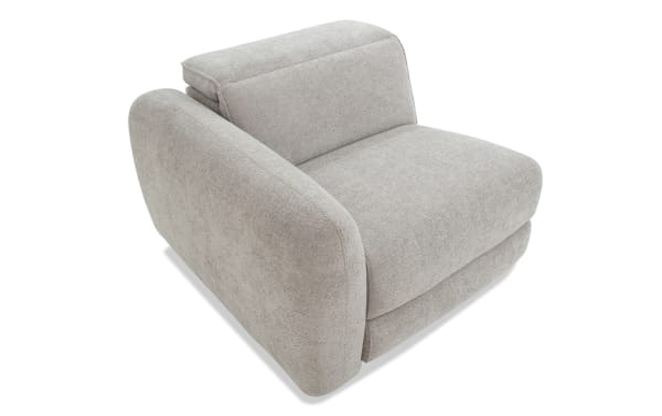 Modern beige fabric armchair with thick cushioned seat and backrest, featuring wide padded armrests and a soft textured upholstery.