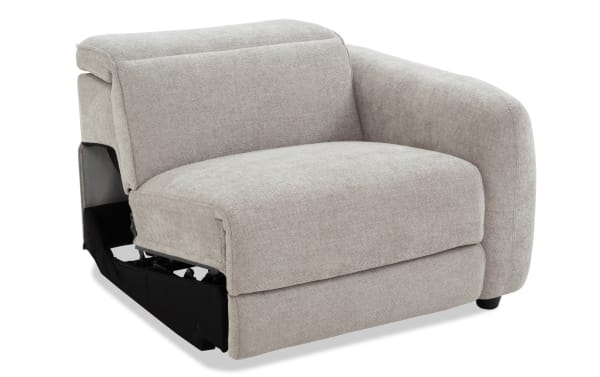 Light gray fabric upholstered recliner chair with a curved armrest and cushioned seat, showcasing the extended footrest mechanism.