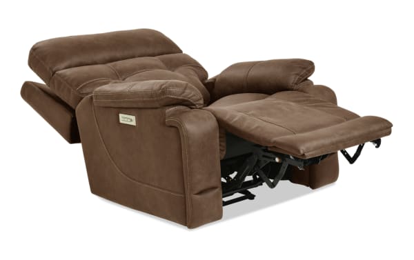 Brown microfiber reclining chair with plush cushioning, padded armrests, and visible metal reclining mechanism, designed for comfort and relaxation.