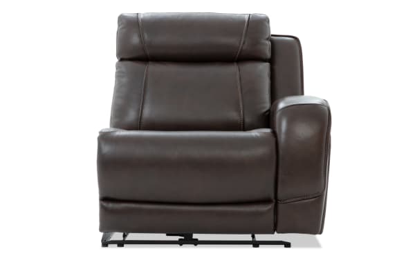 Dark brown leather recliner chair with padded armrest and cushioned backrest, featuring visible stitching and metal reclining mechanism.