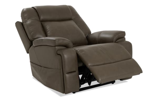 Dark brown leather recliner chair with padded armrests and cushioned backrest, featuring an extended footrest for enhanced comfort.