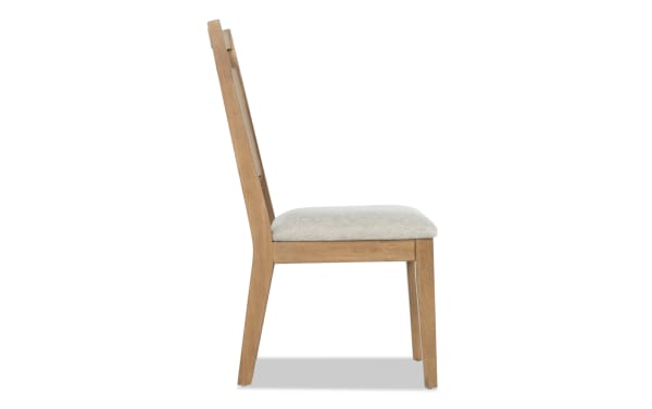 Side view of a wooden dining chair with a beige upholstered seat cushion and a slatted backrest, showcasing a modern minimalist design.