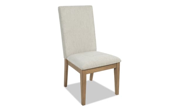 Upholstered dining chair with beige fabric seat and backrest, supported by light brown wooden legs, suitable for modern home decor.
