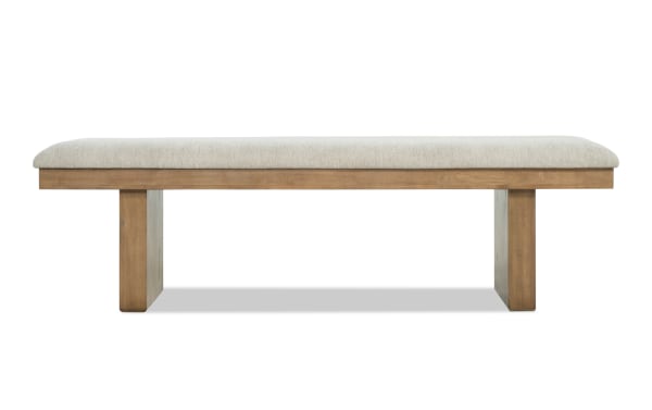 Wooden bench with light beige cushioned seat, featuring a simple, modern design with sturdy rectangular legs, suitable for indoor seating.