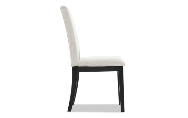 Upholstered dining chair with beige fabric seat and backrest, black wooden legs, and modern minimalist design.