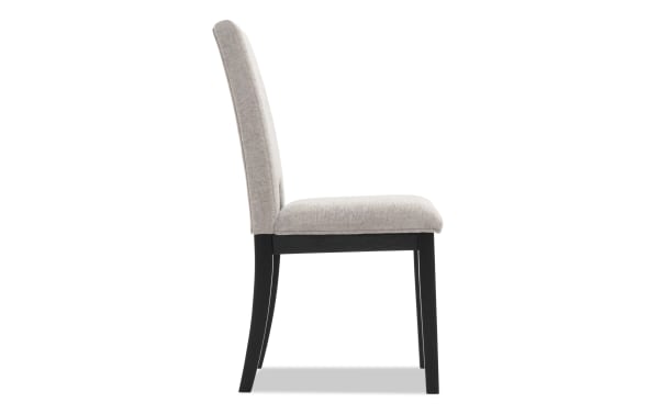 Upholstered dining chair with beige fabric seat and backrest, black wooden legs, modern minimalist design for home or office seating.