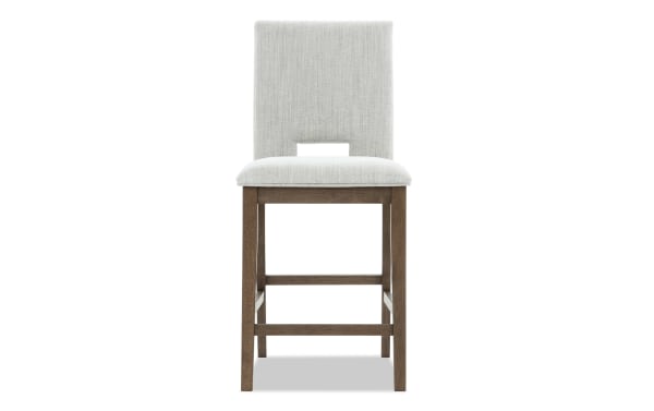 Upholstered bar stool with light gray fabric seat and backrest, wooden legs with footrest, modern dining or kitchen seating.