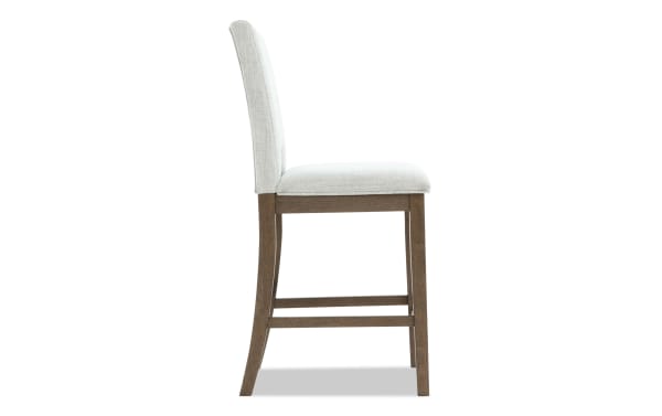 Upholstered bar stool with light gray fabric seat and backrest, solid wood frame in dark brown, side view, modern dining seating.