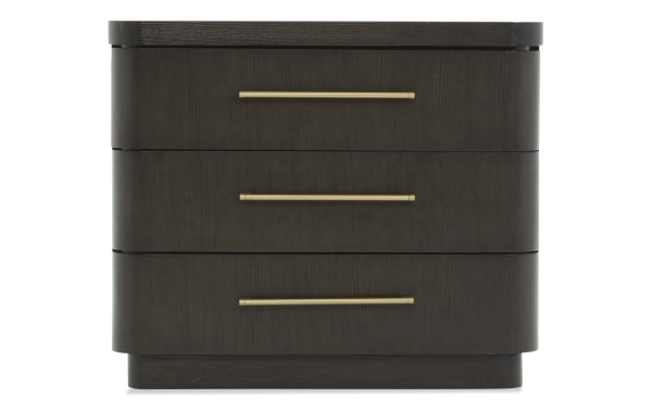 Dark wood three-drawer nightstand with rounded edges and long horizontal brass handles, modern bedroom furniture design.