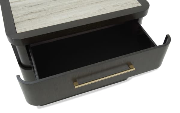 Dark wood drawer with a gold metal handle, partially open, featuring a light wood top surface, showcasing modern furniture design.