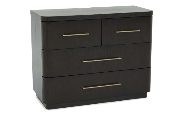 Dark wood dresser with four drawers, featuring sleek brass handles and rounded edges, ideal for modern bedroom storage.