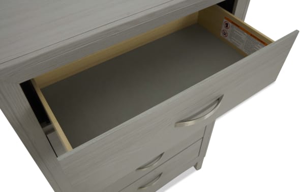 Trinity Gray 5 Drawer Chest in transitional style, made of durable rubberwood with smooth-gliding drawers and a felt-lined top drawer for delicate items.