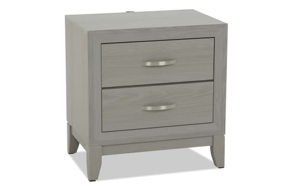 Modern gray wooden nightstand with two drawers, silver curved handles, and tapered legs, suitable for bedroom storage and decor.