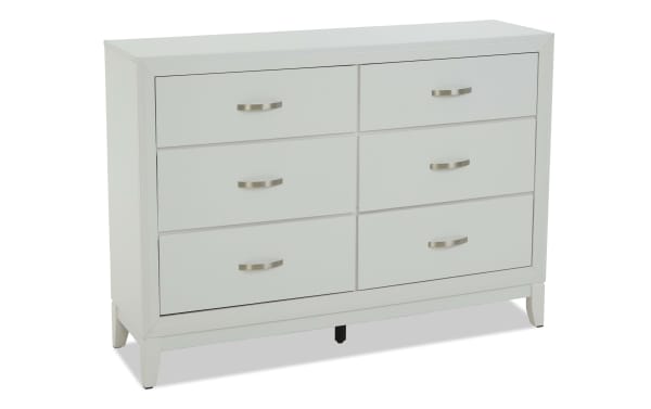 White wooden dresser with six drawers, modern brushed metal handles, and tapered legs, suitable for bedroom storage furniture.