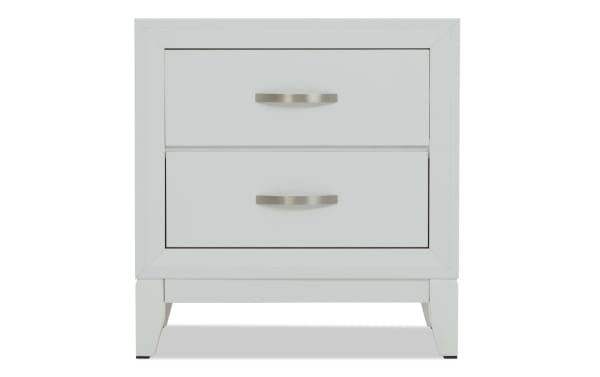 White wooden nightstand with two drawers, brushed metal handles, and a modern, clean-lined design.