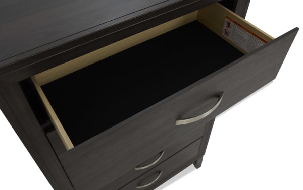 Dark wood dresser drawer open, showing black felt-lined interior and metal curved handle, highlighting storage space and modern design.
