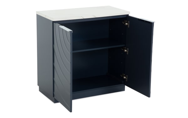 Modern navy blue storage cabinet with two open doors, featuring a white marble-style top, interior shelf, and wave-patterned door design.
