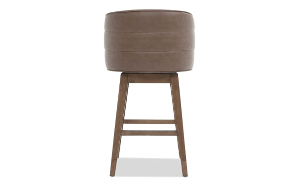 Brown leather cushioned bar stool with wooden legs and footrest, featuring a modern, round seat design for kitchen or home bar seating.