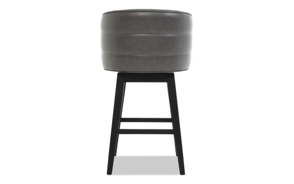Gray leather upholstered bar stool with black wooden legs and horizontal support bars, featuring a modern round cushioned seat.